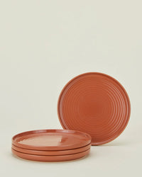 Four Essential Salad Plates in Terracotta from Hawkins New York are shown—three stacked, one standing upright behind. Part of the brand’s dinnerware collection.