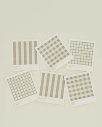 The Hawkins New York Essential Swedish Dishcloths in Ivory/Flax (set of 6) feature assorted beige geometric designs, like stripes and grids, arranged on an off-white background for a modern look.