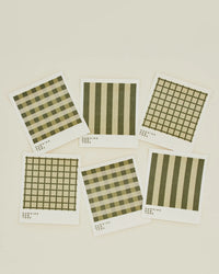 The Hawkins New York Essential Swedish Dishcloths in Olive/Sage, set of 6, feature assorted plaid and striped patterns, arranged on a plain cream background.