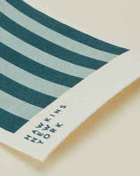 The Essential Swedish Dishcloths in Sky/Peacock by Hawkins New York—set of 6 with dark and light blue stripes and HAWKINS NEW YORK printed in black—are stylish, eco-friendly additions to your kitchen.