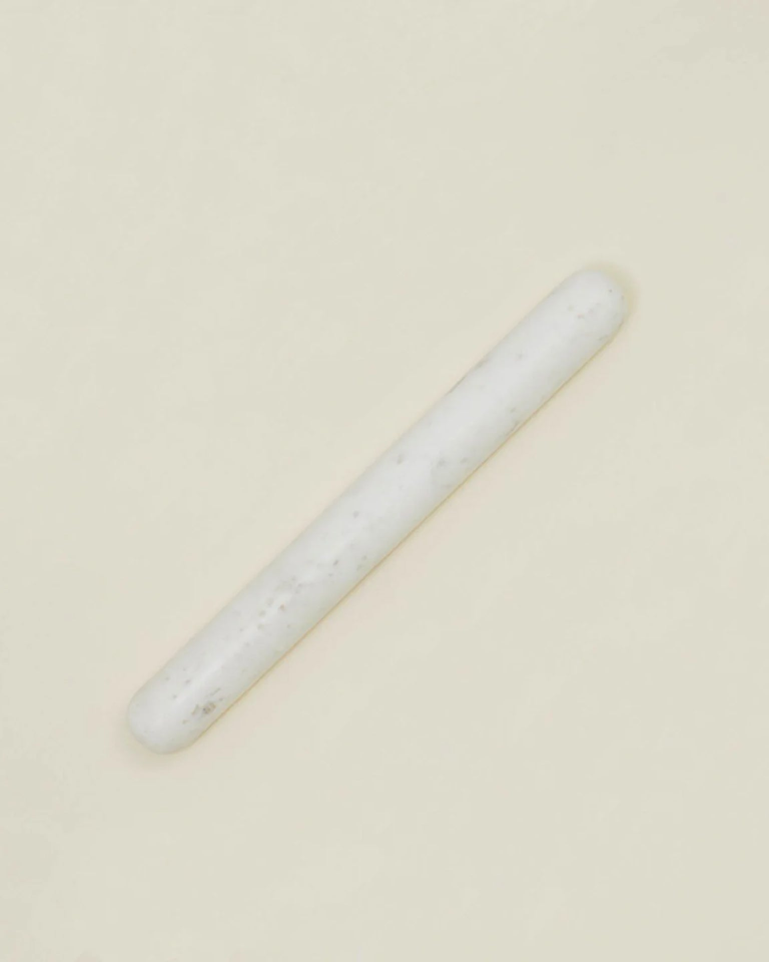 A single Simple Marble Rolling Pin by Hawkins New York is centered on a plain, light beige background, showcasing its sleek white cylindrical design.