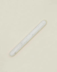A single Simple Marble Rolling Pin by Hawkins New York is centered on a plain, light beige background, showcasing its sleek white cylindrical design.