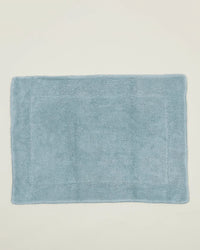 The Hawkins New York Simple Terry Bath Mat in Sky, featuring a soft, plush texture and rectangular shape, is displayed against a plain off-white background.