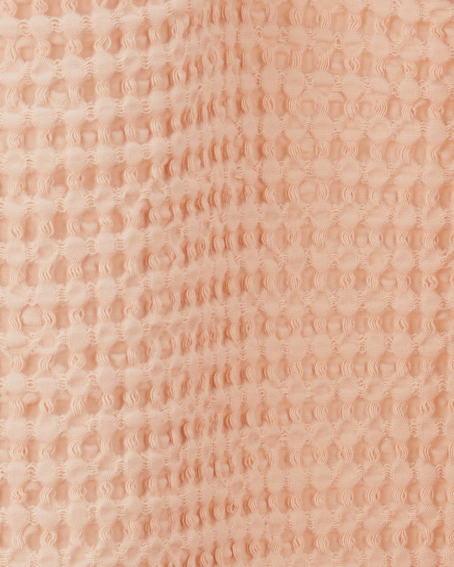 Close-up of the Simple Waffle Shower Curtain in Blush by Hawkins New York, featuring a raised, waffle-textured cotton design.