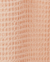 Close-up of the Simple Waffle Shower Curtain in Blush by Hawkins New York, featuring a raised, waffle-textured cotton design.