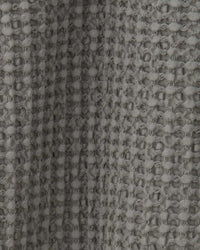 Close-up of the textured fabric with a waffle weave pattern on the Hawkins New York Simple Waffle Shower Curtain in Dark Grey.