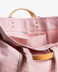 A close-up of an open IMMODEST COTTON Large East West Tote in Bubblegum, featuring tan leather handles and an inner pocket, set against a plain white background.