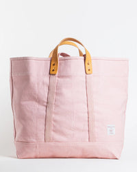 The IMMODEST COTTON Large East West Tote in Bubblegum is a large pink canvas bag with tan leather handles and a small white label near the bottom corner, shown against a plain white background.
