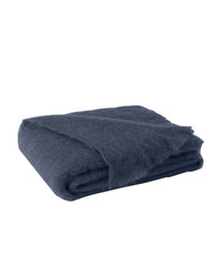 The Brushed Mohair Throw in Indigo by Lands Downunder is a soft, folded accent blanket shown against a white background—an inviting luxury piece woven in New Zealand.