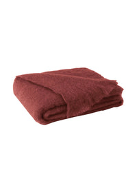 The Lands Downunder Brushed Mohair Throw in Russet features soft, textured edges and a fluffy finish, adding a luxury accent. Beautifully woven in New Zealand, it is shown folded on a white background.