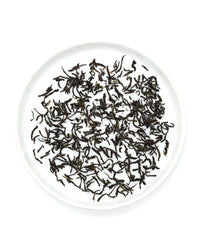 Onyx Coffee Lab’s Earl Grey Tea sachets are arranged on a round white plate.