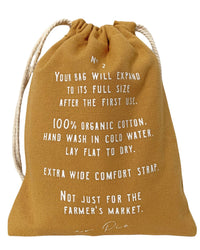 The French Market Bag No.2 in Goldenrod by PILLOWPIA is a reusable, 100% organic cotton bag with an extra-wide strap and multipurpose use—care info printed in white—perfect for daily essentials.