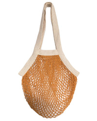 The French Market Bag No.2 In Goldenrod by PILLOWPIA features beige handles and an orange mesh body made from organic cotton, inspired by classic French market bags. Reusable and eco-friendly.