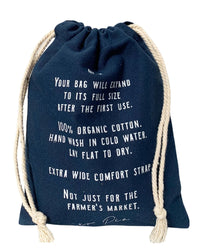 The French Market Bag No.2 in Navy by PILLOWPIA is made from 100% organic cotton with white text detailing care instructions and wide comfort straps—ideal for a chic, eco-friendly carryall.