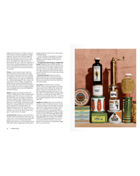 A variety of food products, including bottles, cans, and jars, are neatly stacked on a pink surface beside a wall of text with easy entertaining recipes inspired by Nothing Fancy from Random House.