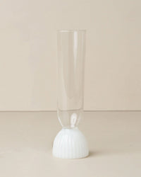 The Kairos Champagne Flute in Opaque White by Saarde features a sleek design, shown on a neutral surface with a beige background.