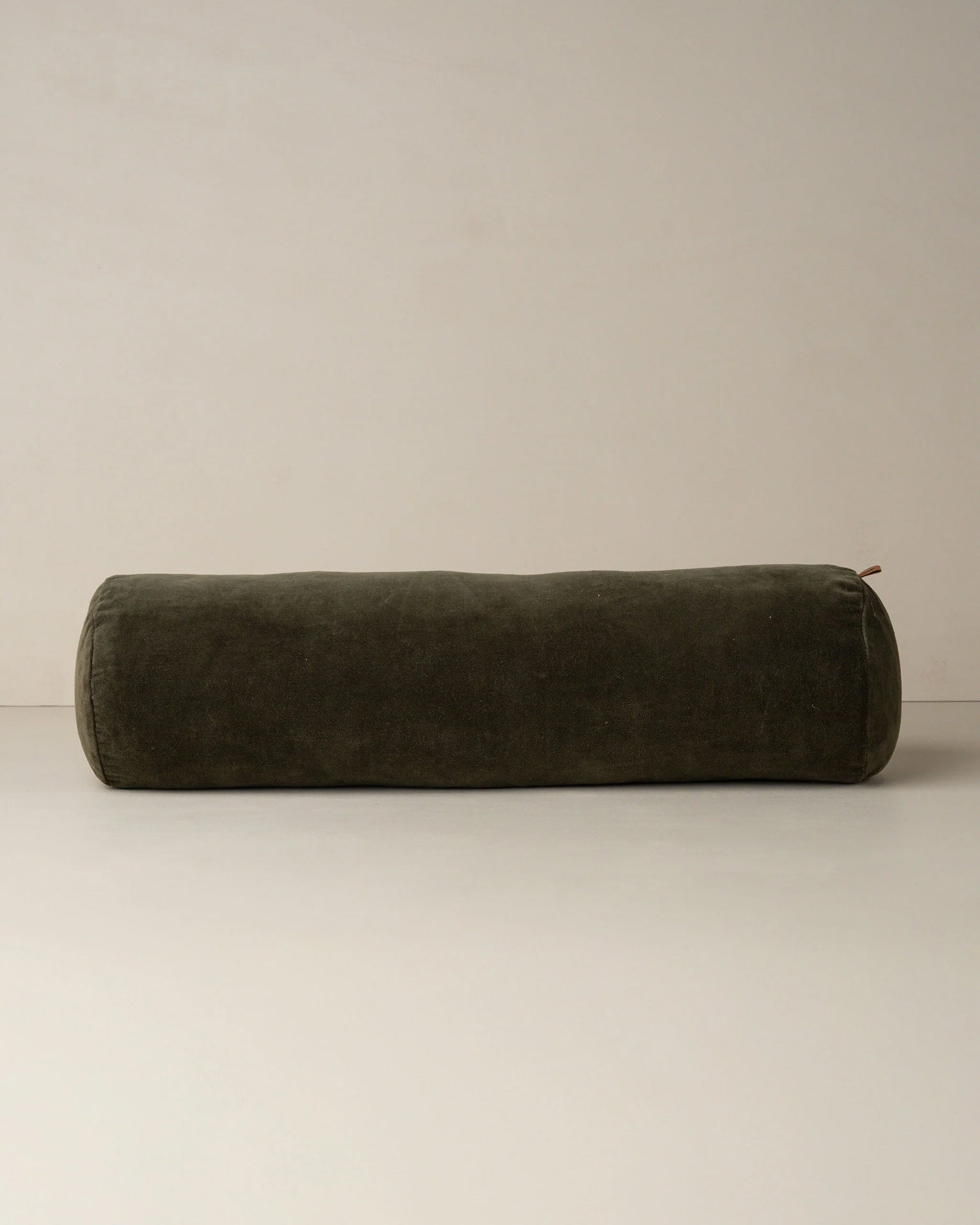 The Saarde Velvet Structured Bolster in Dark Olive is displayed on a plain light surface with a neutral backdrop.