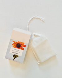 A box labeled Everyday - Handmade Soap by The Quiet Botanist sits next to a white drawstring pouch on a light surface—ideal for sensitive skin and featuring a gentle, natural fragrance.