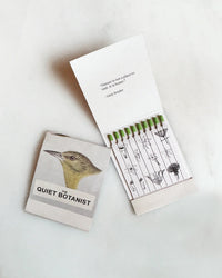 Golden Finch - Botanical Matches by The Quiet Botanist: a limited edition matchbook with a bird illustration, green-tipped biodegradable matches, botanical drawings, floral accents, and a Gary Snyder quote inside.