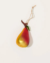The Cody Foster Orchard Pear in Red + Yellow is a hand-crafted glass Christmas ornament with a yellow-to-red gradient, brown stem, green leaf, and hanging string, shown against a plain white background.