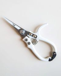 The Jungle Club Pruning Shears in White feature a sturdy metal blade and spring mechanism, with white handles, shown resting on a plain white surface.