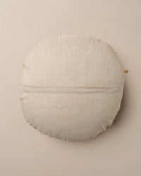 The Saarde Linen/Velvet Round Pillow with Feather Insert in Stone features a soft beige hue and subtle texture, displayed on a matching background.