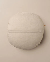The Saarde Linen/Velvet Round Pillow with Feather Insert in Clay features a light beige tone, subtle horizontal center seam, and soft texture, shown against a plain neutral background.