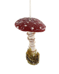 The Amanita Muscaria hanging ornament by Cody Foster features a hand-crafted red and white spotted mushroom with a textured stem, moss at the base, and is suspended by a string.