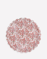 The Meri Meri x Liberty Red June's Meadow Small Tray by Meri Meri features a round, scalloped-edge design with a red background, decorated with intricate white and blue flowers and green leaves.