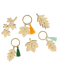 Meri Meri x Liberty Fall Crackers with Velvet Bows by Meri Meri are ideal for a fall dinner table. This set includes five leaf-shaped wooden keychains with metal rings and colored tassels—orange, green, and light blue.