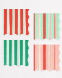 Four Festive Stripe Small Napkins by Meri Meri, each with wavy edges and vertical red, green, mint, and peach stripes, are displayed in a grid on white—ideal as holiday cocktail napkins.