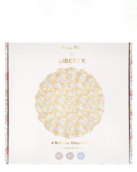 A box of four “Meri Meri X Liberty Mixed Set Reuseable Large Plates” features a yellow floral Liberty print and gold and black branding. Three small patterns decorate the bottom. Brand: Meri Meri.
