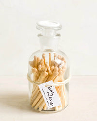 LEIF’s Apothecary Jar Matches in Nougat come in a clear jar with a white wax seal and string-tied label reading “safety matches.”.