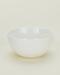 A set of four Simple Porcelain Large Bowls by Hawkins New York is displayed on a light neutral surface with a minimal, uncluttered background.