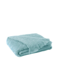 The Lands Downunder Brushed Mohair Throw in Sea Spray is a folded, light blue, fluffy blanket with a soft, fuzzy texture and fringed edges, shown against a plain white background.