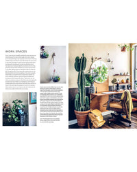 Wild Interiors by Simon & Schuster inspires a home office with a wooden desk, leather chair, and potted cactus, creating a refreshing workspace filled with houseplants and natural light.