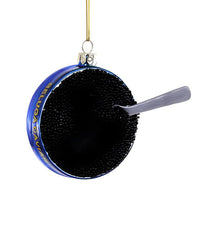 The Beluga Caviar Ornament by Cody Foster is a blue tin with gold accents, a gray spoon inside, and hangs from a gold string—capturing the brand's signature charm in this festive decoration.