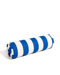The Bolster Pillow - Crew Mediterranean Blue Stripe by Business & Pleasure Co is a cylindrical pillow with wide blue and white stripes, perfect for indoor or outdoor use, shown on a white background.