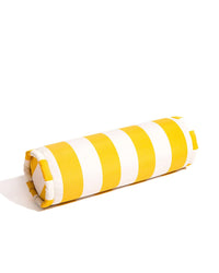 The Crew Mimosa Yellow Stripe Bolster Pillow by Business & Pleasure Co adds stylish comfort to any indoor or outdoor space with its yellow and white striped design.