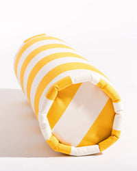 The Crew Mimosa Yellow Stripe Bolster Pillow by Business & Pleasure Co features alternating yellow and white stripes, pictured on its side against a white background. Ideal for versatile indoor or outdoor comfort and style.