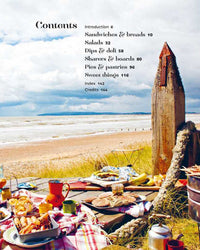 A beach picnic scene with food on a blanket and a backdrop of sand, sea, and sky showcases outdoor dining. Overlaid is the table of contents from "Picnic" by Simon & Schuster, featuring delicious picnic recipes.