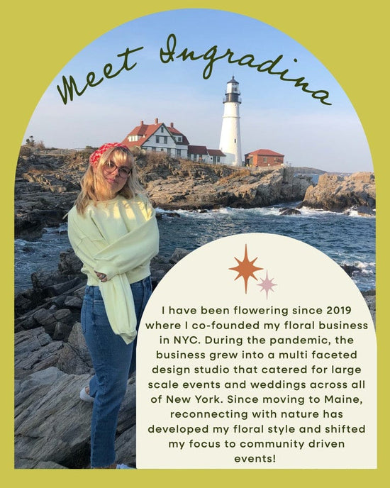 A smiling woman in sunglasses and a light green sweater stands by rocky cliffs and a white lighthouse, inviting you to Baske’s Thanksgiving - Floral Workshop to celebrate her NYC-to-Maine floral design journey by the ocean.