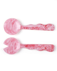 The Casa Amarosa Resin Salad Server Set in Pink features two handmade servers—one solid, one slotted—with wavy handles, arranged side by side on a white background for a striking display.