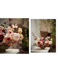 The Artistry of Flowers by Random House features a vibrant floral arrangement in a ceramic bowl with pink, white, and burgundy flowers. Set near trailing green plants, it’s an elegant decor accent for any neutral space.