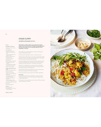 A bowl of crab curry with rice noodles, herbs, and red chili sits on a white plate with chopsticks and green onions—an ideal photo for "Thai Made Easy" by Chronicle Books or your easy Thai recipe collection.