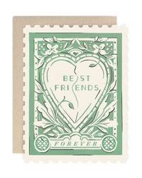 The Best Friends Forever Stamp single card by Amy Heitman features a green heart with "BEST FRIENDS" and "FOREVER," surrounded by flowers and leaves, designed like a postage stamp with a brown envelope included.