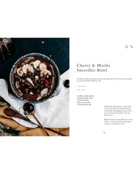 A cherry and mocha smoothie bowl topped with banana, cherries, chocolate granola, and shavings sits in a ceramic bowl—perfect breakfast inspiration from "Wonderful Morning - Recipes For A Delicious Start To the Day" by Cozy Publishing.