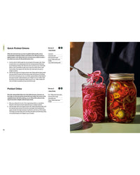 An open copy of "The Salad Project" by Random House displays quick pickled onion and chile recipes, as a hand lifts onions from a jar—perfect for enhancing salad recipes or homemade dressings.