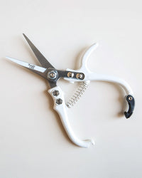 The Jungle Club Pruning Shears in White feature a sleek open blade and spring mechanism, shown on a plain light background.