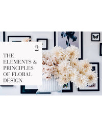 A white vase with blush roses and large white flowers sits before a wall of black-framed butterfly art. Text reads: The Flower School by Chronicle Books—ideal inspiration for any floral design enthusiast or student.